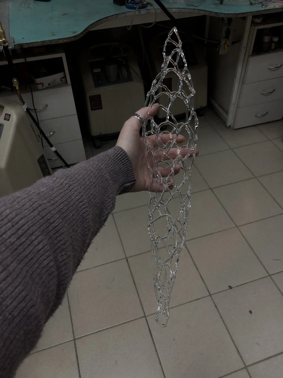 Вертикальная ажурная стеклянная скульптура в руках